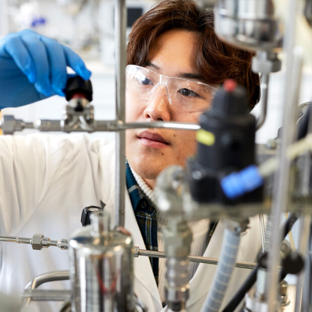 A student adjusts a thread for an experiment in the laboratory