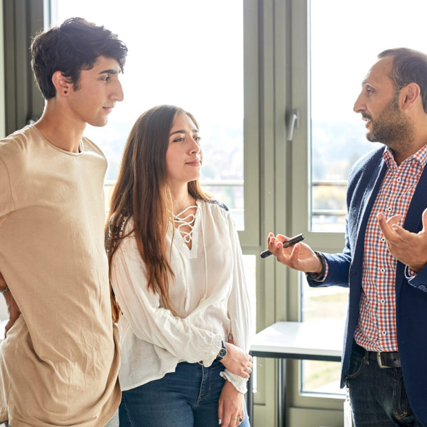 Students talk to a professor about their Bachelor thesis